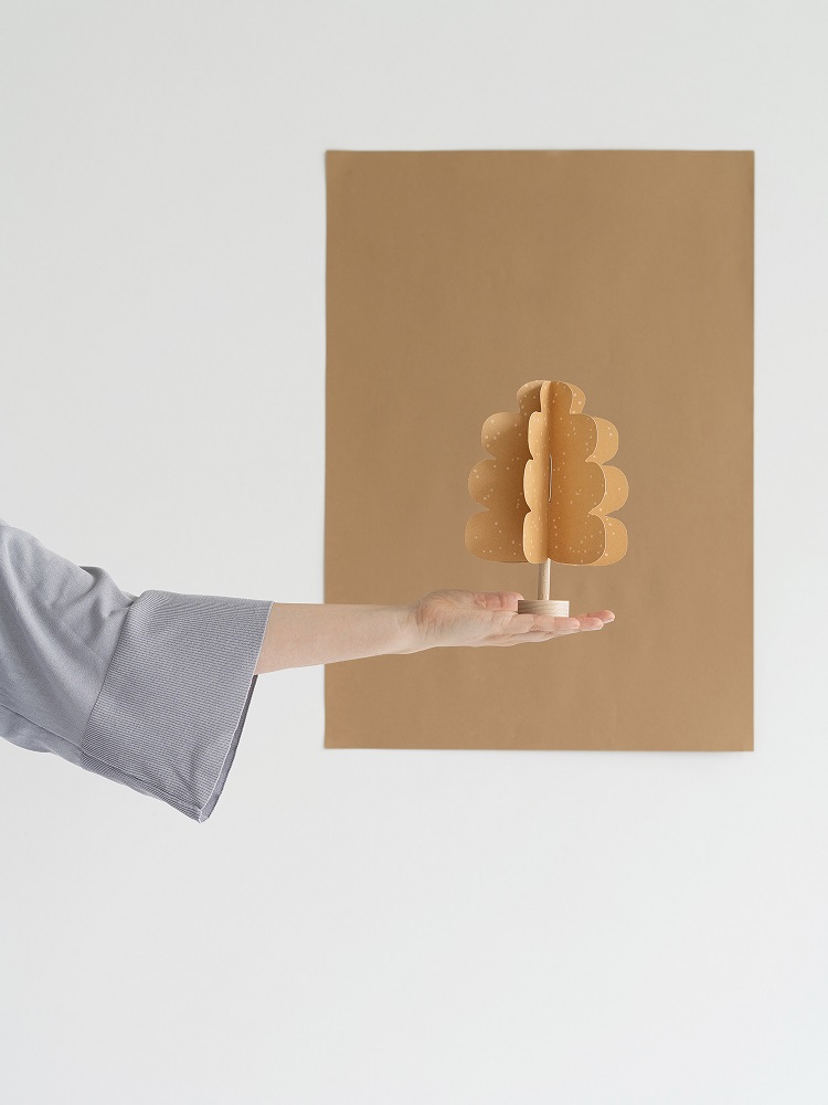 oak-tree-light-brown-2 Papierbaum, beiger Ton, baumförmig, auf Holzstiel, ausgestreckte Hand, weißer Hintergrund.