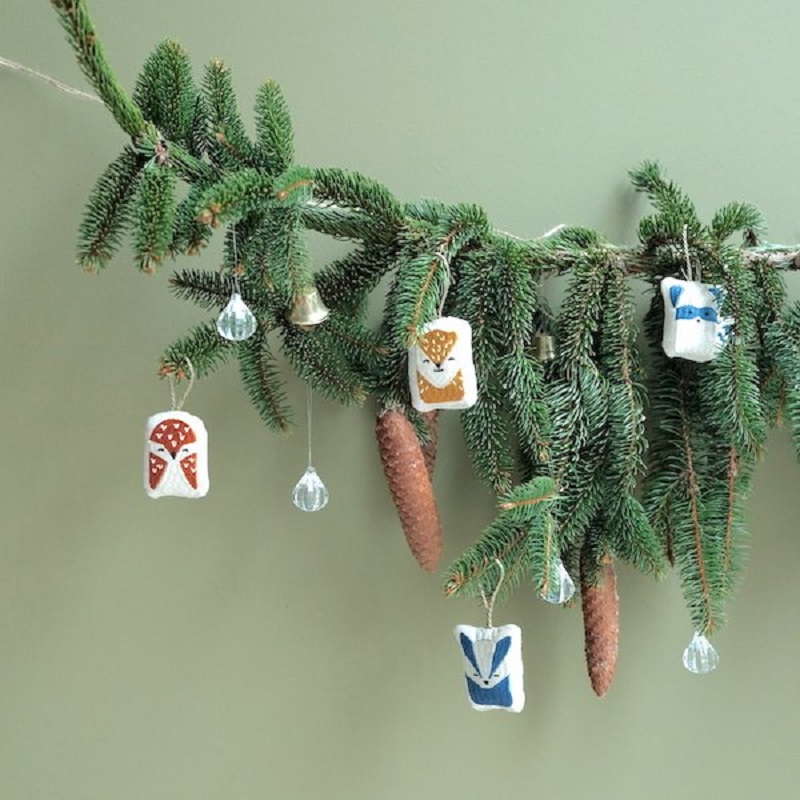 FBL20Ornaments20Hanging2DWoodland20Animals Tannenzweig mit hängenden Dekorationen, Filzanhänger in Tierform, Farben: Braun, Blau, Weiß; Glasornamente in Tropfenform; kleine Metallglocke.