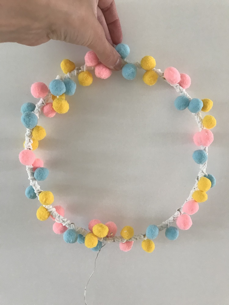 IMG_4946 Bunter Pompon-Kranz, pastellfarben, Blau, Pink, Gelb, handgehalten.