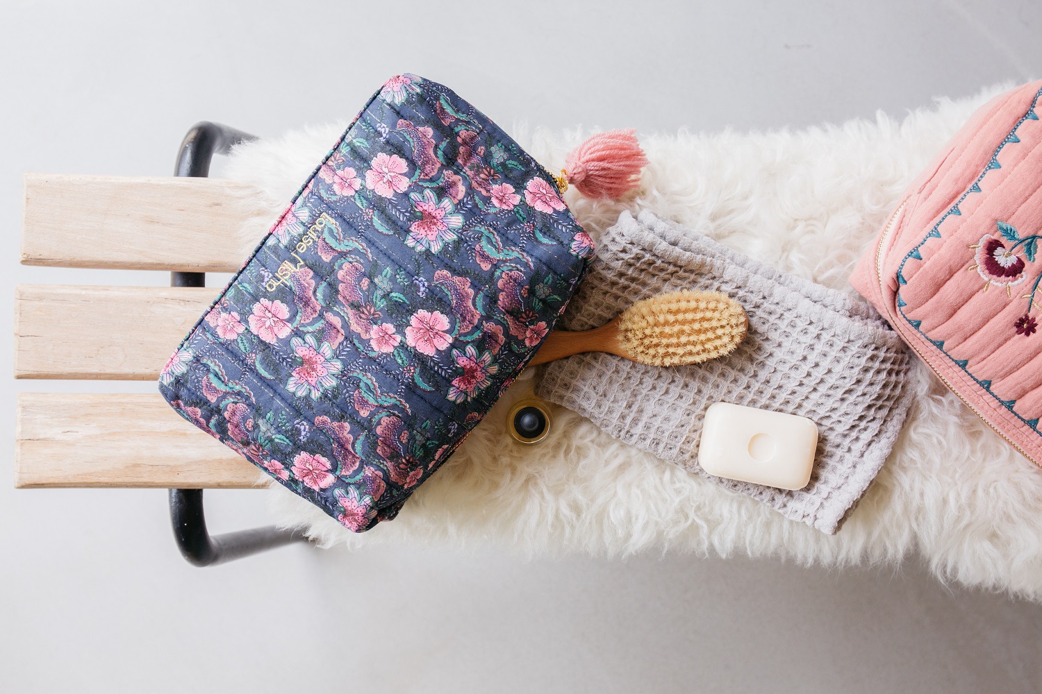 kidslargepocketanelsienna2 Kosmetiktasche, Blumenmuster, dunkler Hintergrund, rosa Quaste; grauer Waschlappen; Holzhaarbürste; weiße Seife.