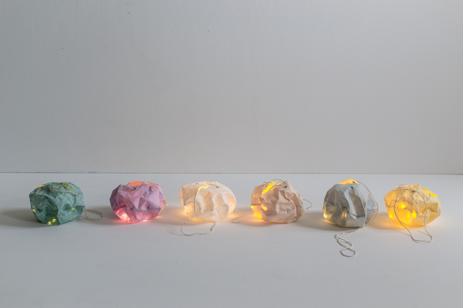DSC_0381 Bunte Papierlampen, sechs Stück, Farben: Grün, Rosa, Beige, Hellbraun, Grau, Hellgelb, mit Glühlichtern, unregelmäßige Formen, Schnuraufhängung