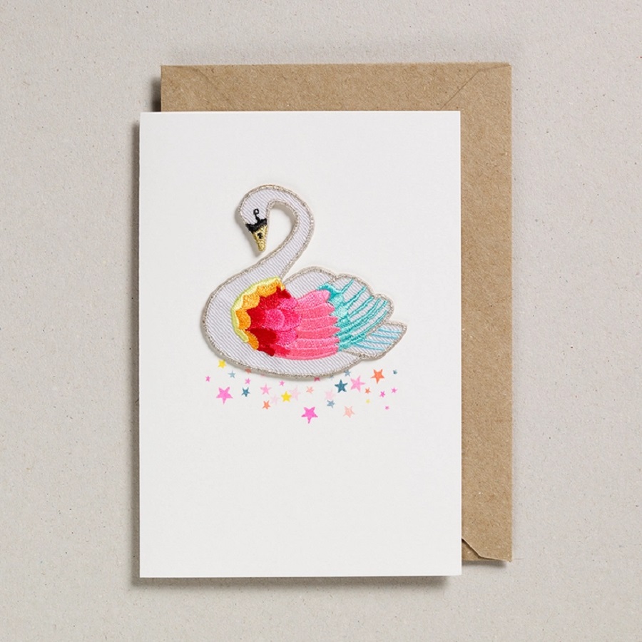 33c9a8245a328df2907737a9e51a6efd91376d8792b51acdd4921fbd2737754c Grußkarte, weiß, bunte Schwan-Applikation, Glitzereffekt, brauner Umschlag, Sternenmuster.