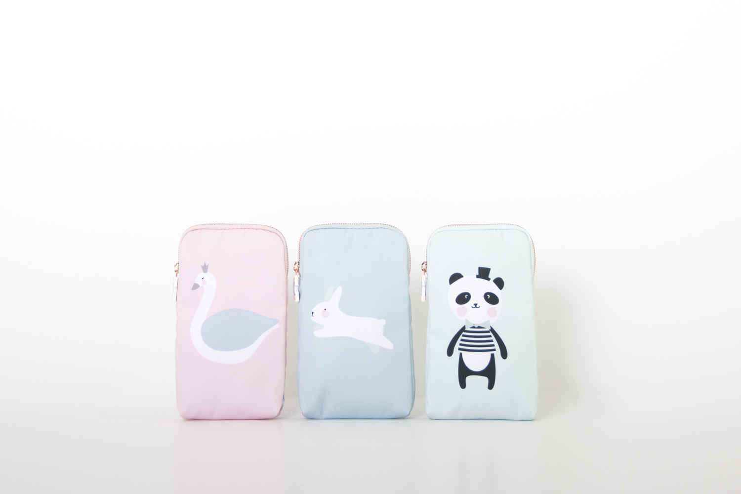 RGR_EefLillemor_pencilcase_all Drei Federmäppchen, pastellig rosa, blau und mintgrün, mit Tiermotiven: Schwan auf rosa, Hase auf blau, Panda auf mintgrün. Reißverschluss oben.