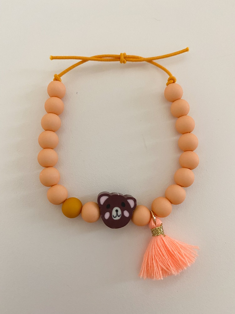 IMG_5319 Armband, orange Perlen, gelbes Band, brauner Bärenanhänger, orange Quaste.