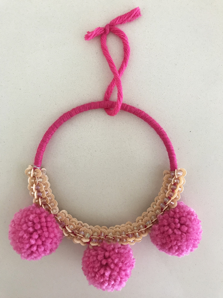 IMG_2699 Dekoration, pinke Wollschnur, beigefarbene Perlen, drei rosa Pompons, runde Form, Aufhängeschlaufe.