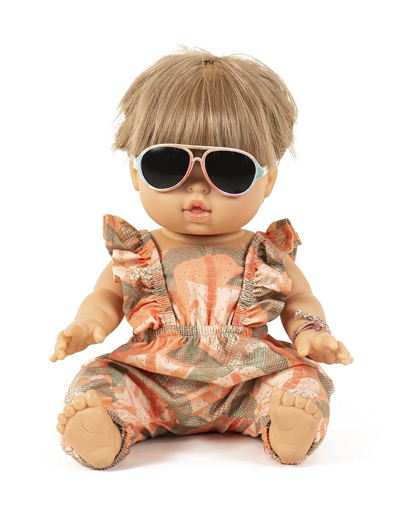 minikane-lunettes-pour-poupees-34cm-sacha3 Puppe, blonde Haare, Sonnenbrille, gemusterter Strampler in Orange und Grün, Armband am linken Handgelenk.