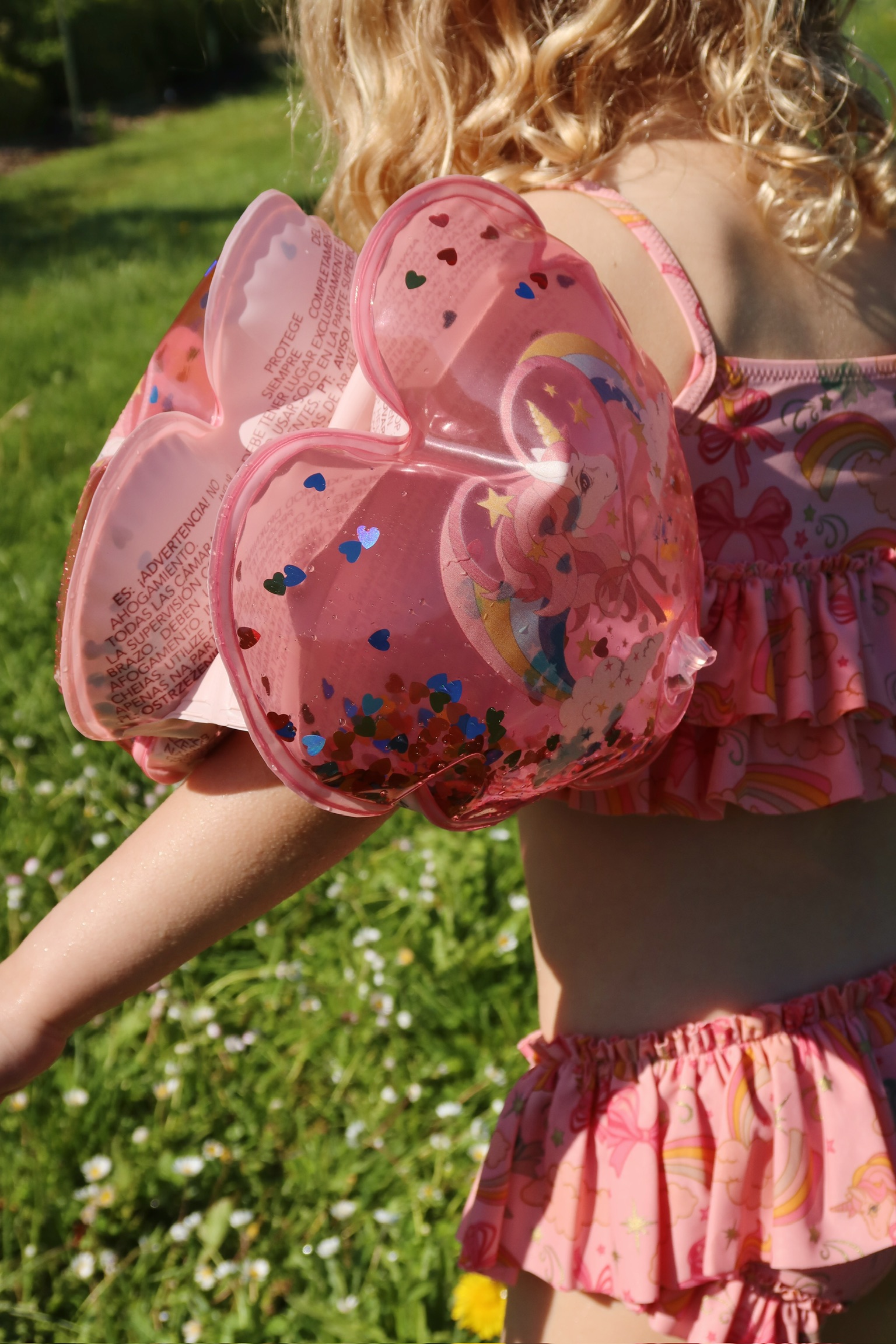 Schwimmflügel, pink, Herzform, Einhorn-Aufdruck, Glitzer, bunte Herzkonfetti.