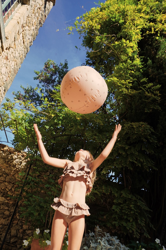 KS2837-BEACH-BALL-CHERRY-Extra-2 Brauner Ball mit Blumenaufdruck, Mädchen in braunem Rüschenbikini, blauer Himmel.