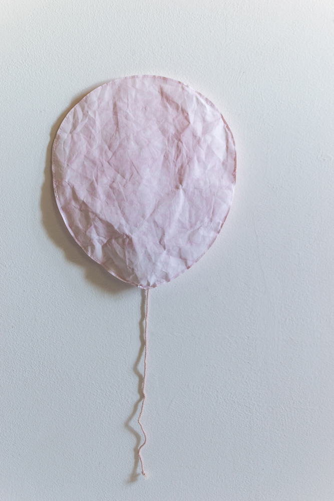 lightpink1 Papierballon, blassrosa, flach, runde Form, Stofffaden an der Unterseite.