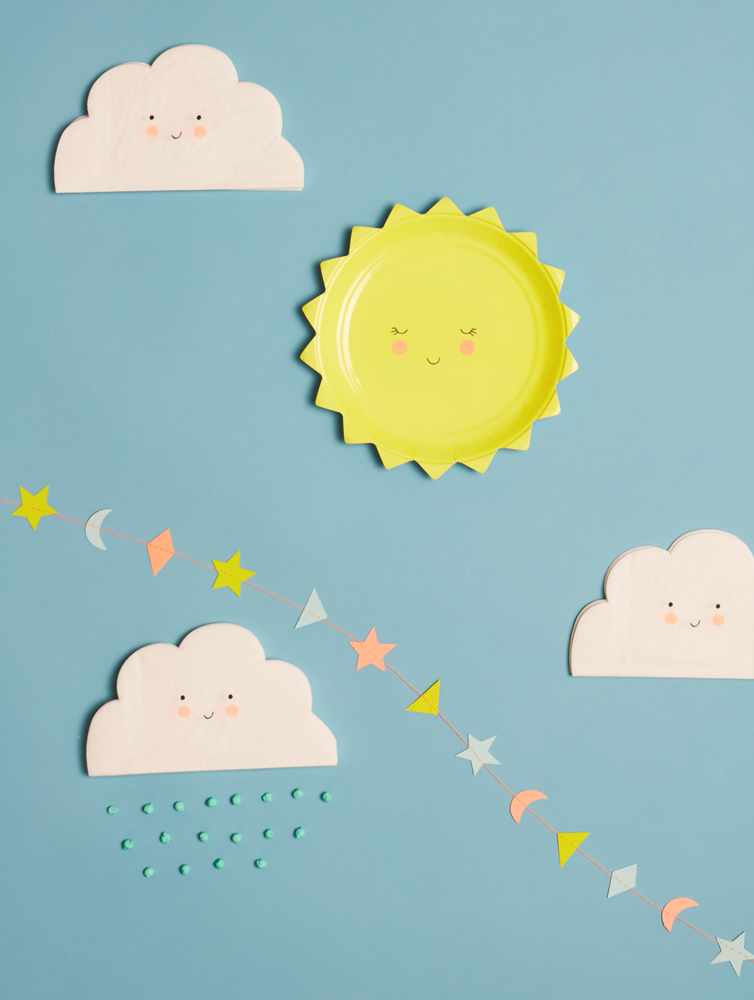 Everyday17-Party-586-E159099791ad911 Gelber Pappteller in Sonnenform mit Gesicht, drei weiße Servietten in Wolkenform mit Gesicht, blaue Perlen als Regentropfen-Design, bunte Papiergirlande mit Sternen, Monden und Drachen auf hellblauem Hintergrund.