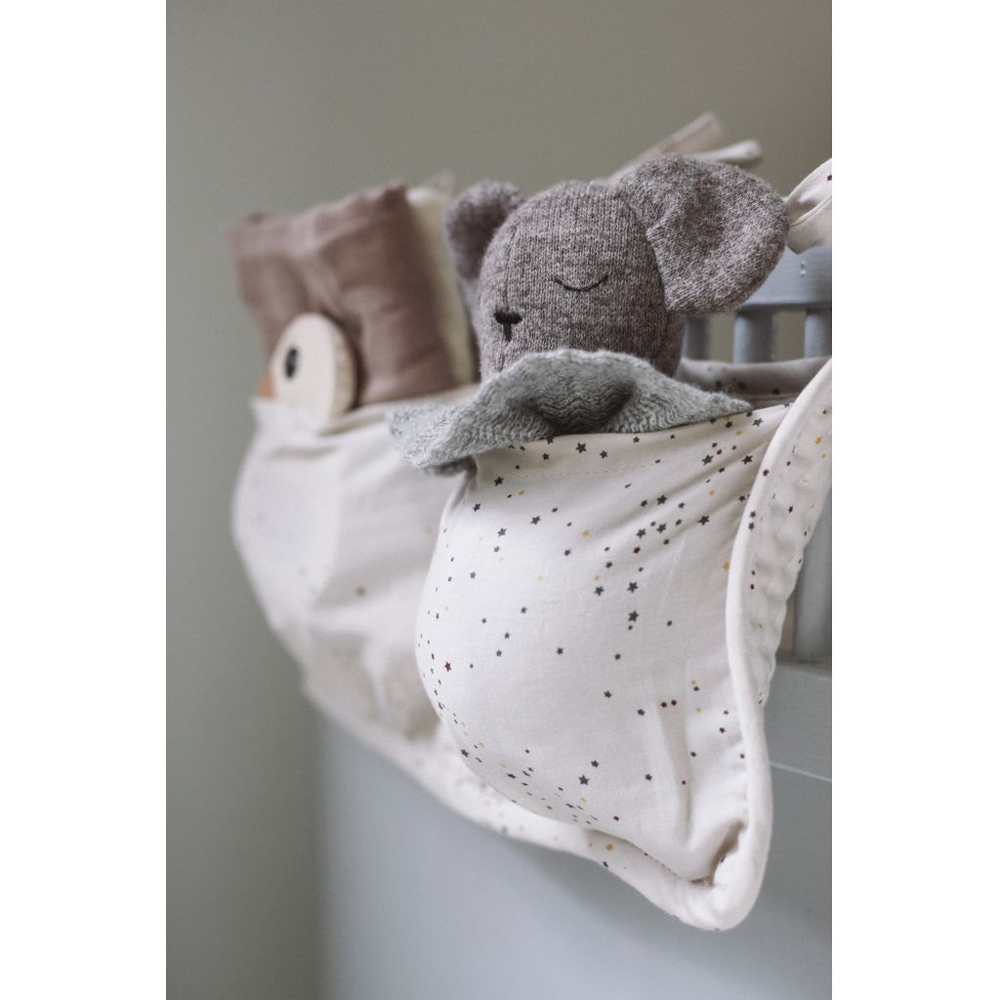 16555-Extra-3 Kinderbett-Organizer, weiß mit kleinen Sternmustern, gefüllt mit einem grauen Stofftier in Koalaform, zweites Fach mit beigem Kissen.