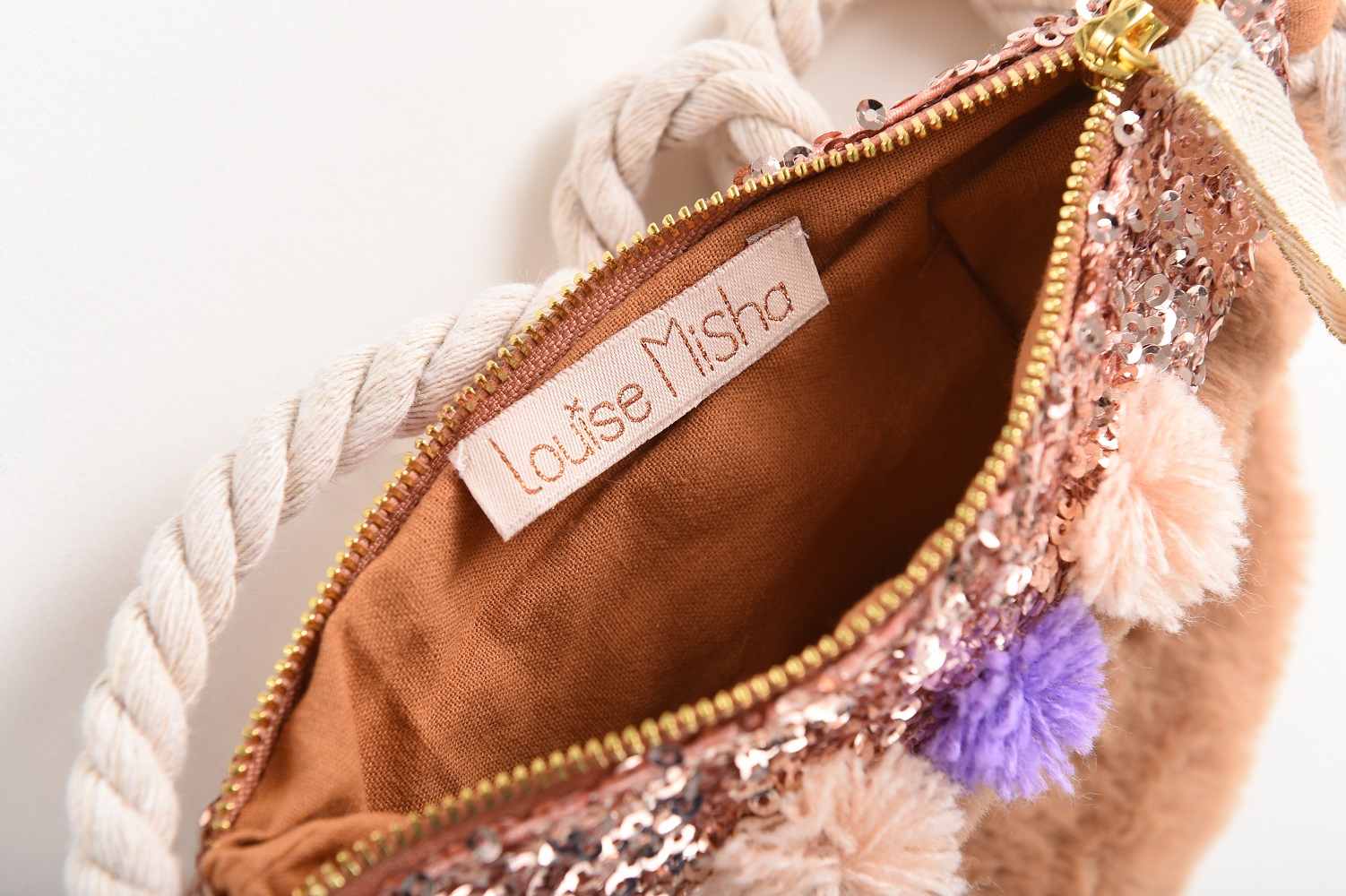 kidsbagazucenanuts9 Tasche, rosa-glitzernde Pailletten, Label "Louise Misha", cremefarbene Strickkordel, Innenfutter in Braun, bunte Pompons in Rosa und Lila.