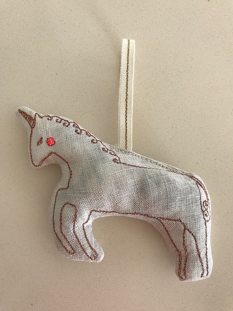 DD0D222D-99C6-4D21-8DD9-2A9A73941289-002 Stoffanhänger Einhorn, beige, rote Stickerei, Aufhängeschlaufe.