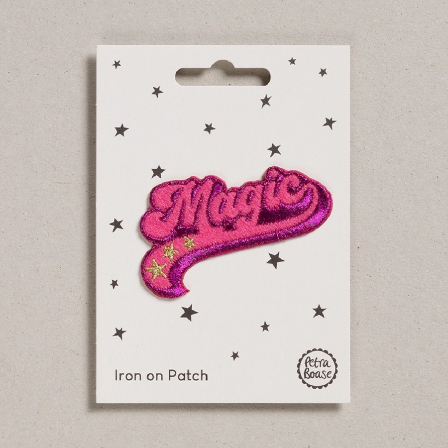 a7f883916dfc7689618bdf589e12ad2f56d631f517d74a980639ace1533452ee Bügelpatch, Schriftzug "Magic", pink, gestickte Sterne, Befestigungskarte weiß mit schwarzen Sternen, rechteckig.
