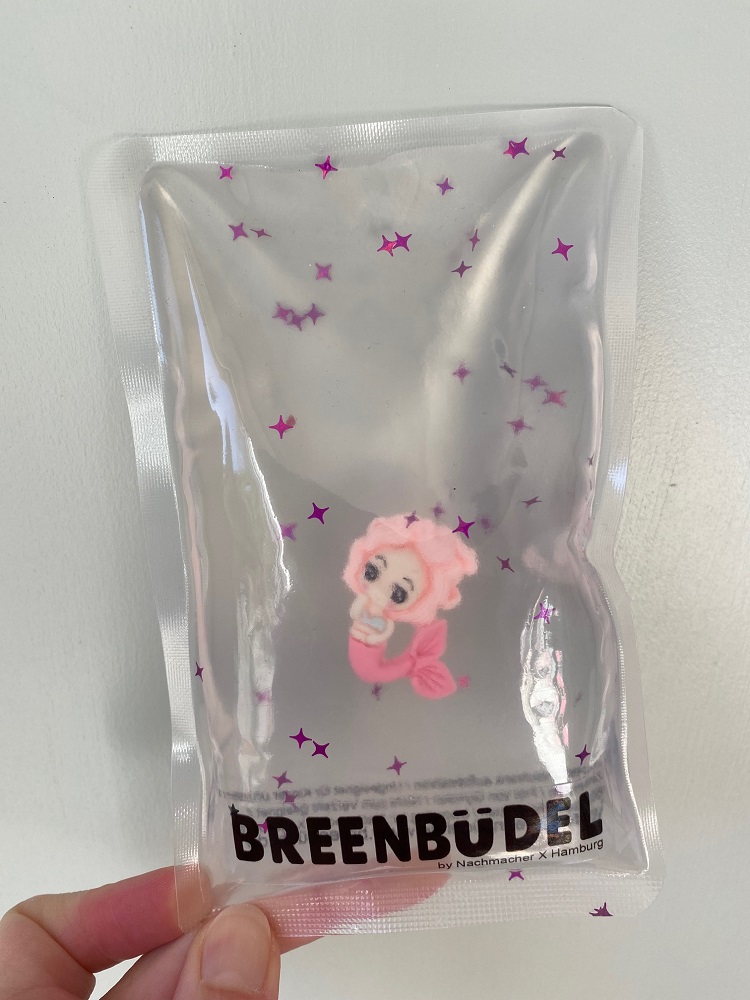 IMG_9039 Transparente Verpackung, rosa Meerjungfrau-Illustration, pinke Sterne, schwarzer Text "Breenbüdel".