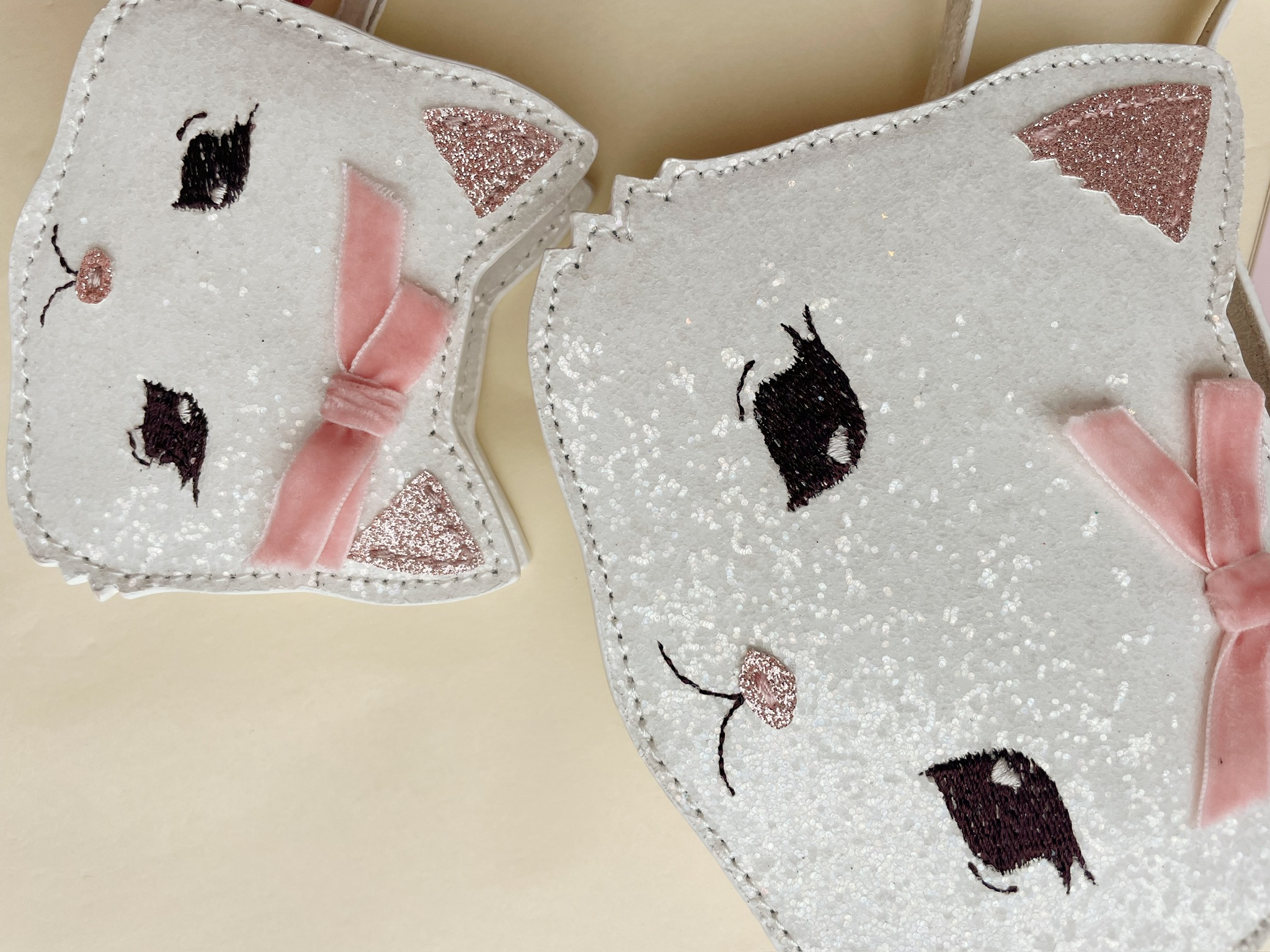 Tasche in Katzenform, weiß glitzernd, rosa Schleife, aufgestickte Augen und Nase, rosa Glitzerohren.