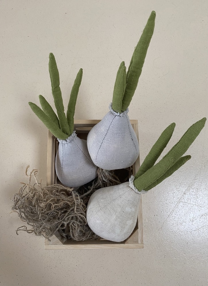 IMG_1285 Deko-Zwiebel aus Stoff, weiß-grau, grüne Blätter, in Holzkiste mit Jutefasern.