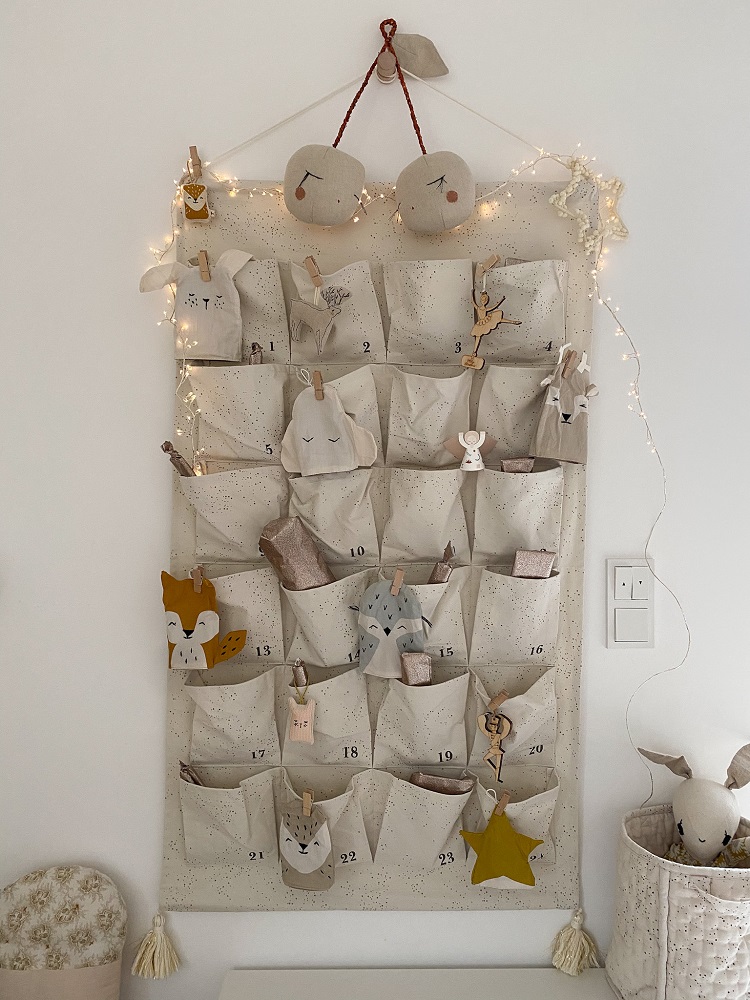 Adventskalender, cremefarben, 24 Taschen, nummeriert, Tiermotive aus Stoff, Clips, Stern, Lichterkette, hängend.