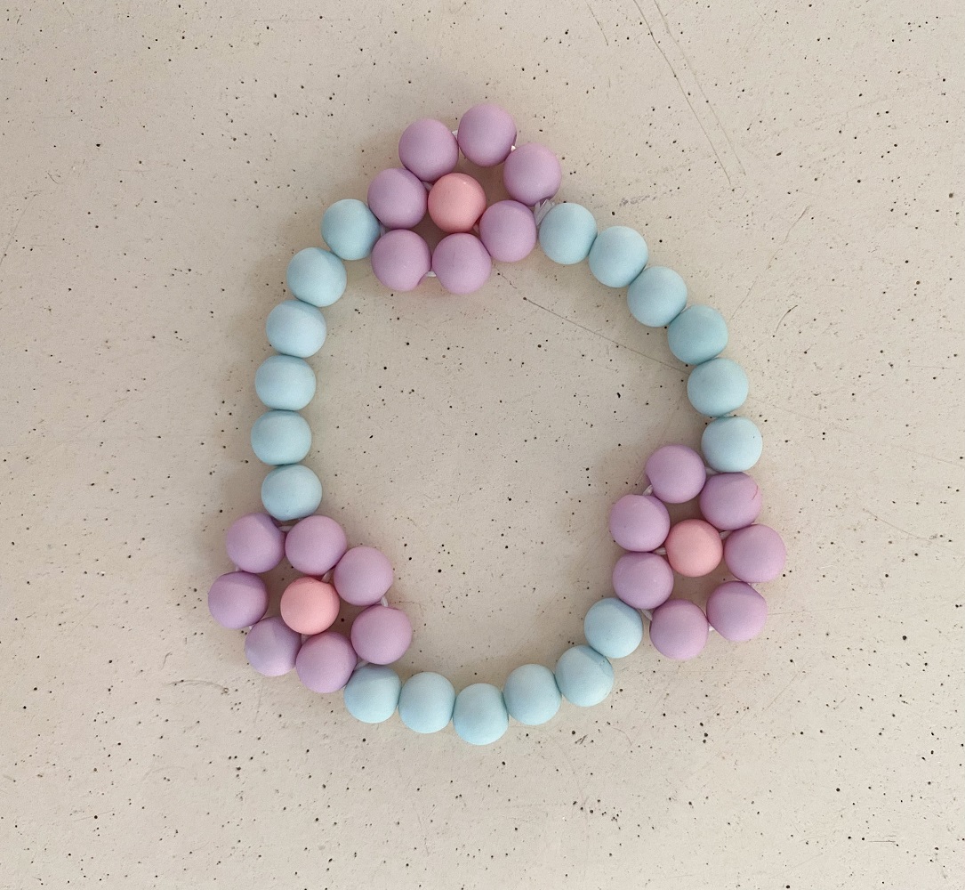 IMG_4936 Perlenarmband, pastellfarben, blaue und lila Perlen, Blumenmuster mit rosa Zentrum.
