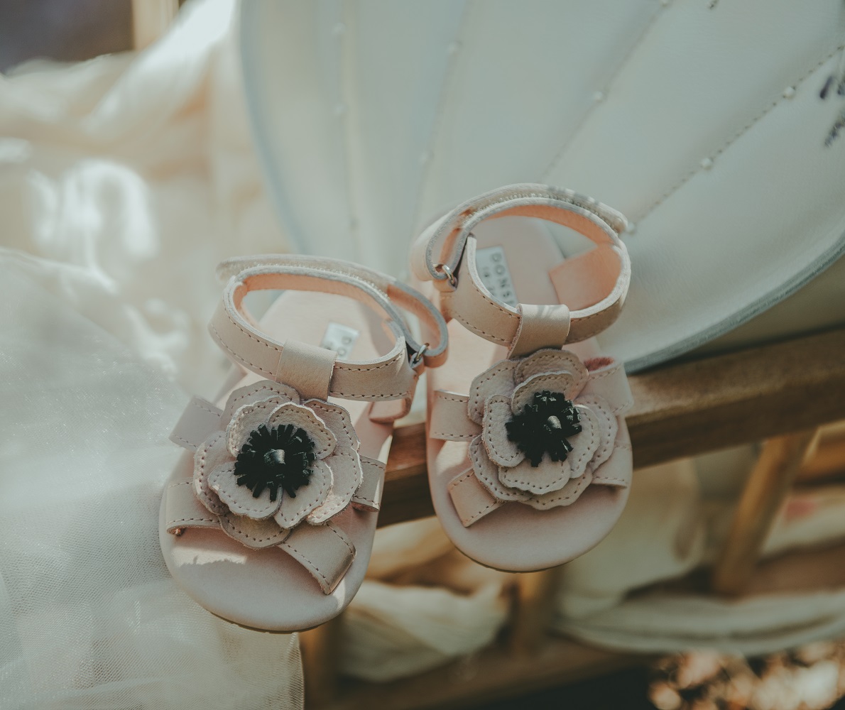 Shoes-Crop-Media-Kit-SS2215 Babysandalen, rosa, blumiges Design, Schleifen, Klettverschluss, zwei Blumenapplikationen mit schwarzem Zentrum.