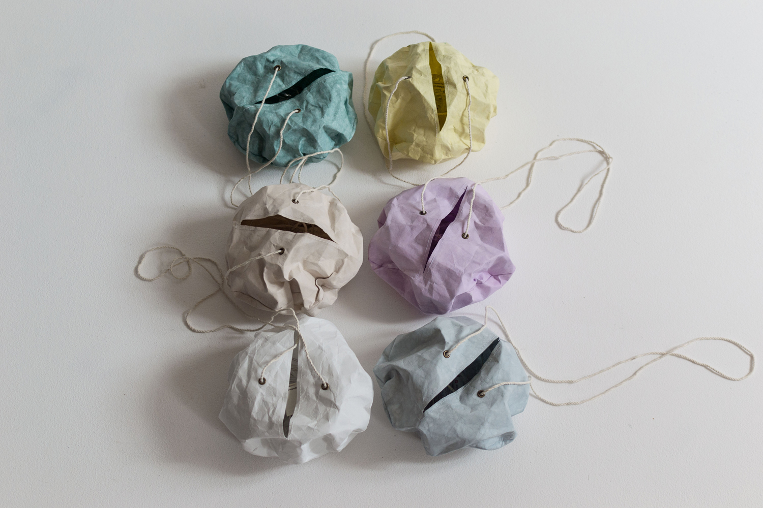 DSC_0517 Papierkugeln, sechs Farben: grün, gelb, beige, lila, weiß, blau; Knitteroptik, jeweils ein Eingriffsschlitz, Kordel zum Aufhängen.