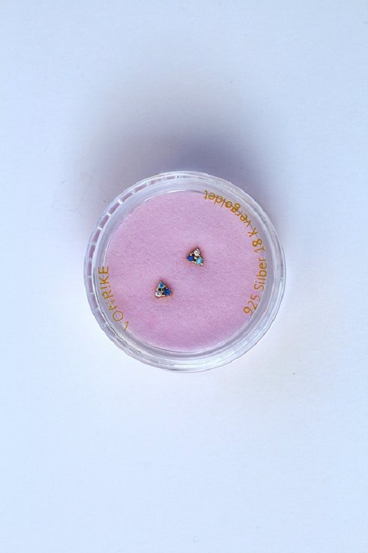 7a75ef_f6c405aca91a4095bb10a6efc0bacee9_mv2 Ohrringe, dreieckig, blau, goldfarben, Verpackung rosa Unterlage, transparenter Behälter.