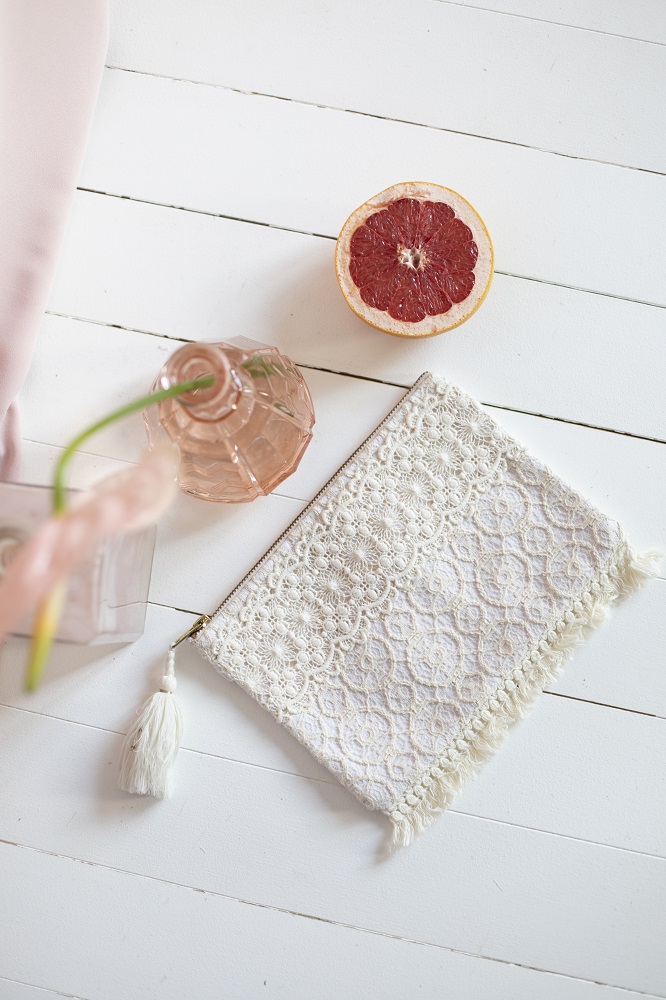 women-pocket-barbara-cream-sparkle-lace-1 Kosmetiktasche, cremeweiß, Spitzenmuster, Quastenanhänger; rosa Vase, halbe Grapefruit