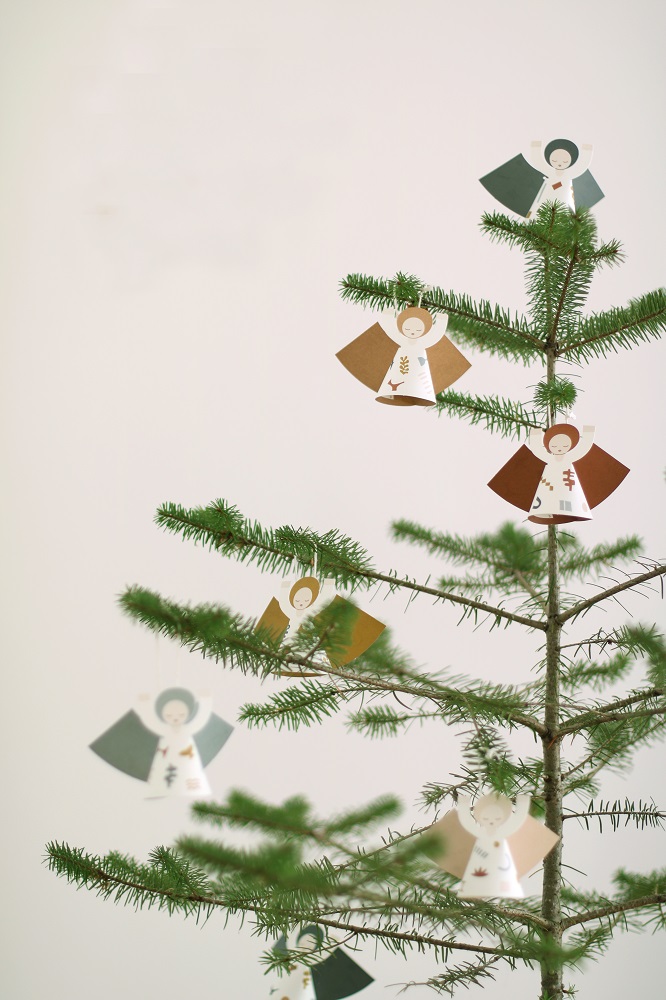 fridur-new-1 Weihnachtsbaumanhänger, Engel aus Papier, Farben: Braun, Grün, Weiß, Aufdruck: Minimalistische Gesichter und Muster.