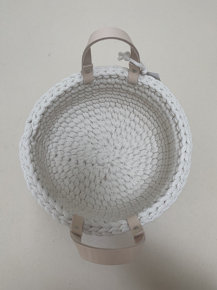 IMG_1698 Geflochtener Korb, rund, cremeweiß, zwei beige Tragegriffe aus Leder, handgefertigt, Zopfmuster, minimalistisches Design.