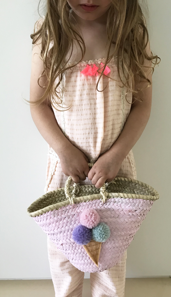 IMG_2886 Korb-Tasche, Strohmuster, pastellrosa, Eiscreme-Applikation mit bunten Pompons, Griffe geflochten, getragen von Mädchen in rosa Kleidung.